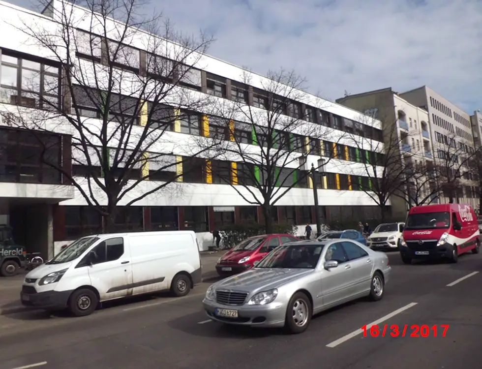 Weißer Fassadenbau eines großen Gebäudes an einer Straße